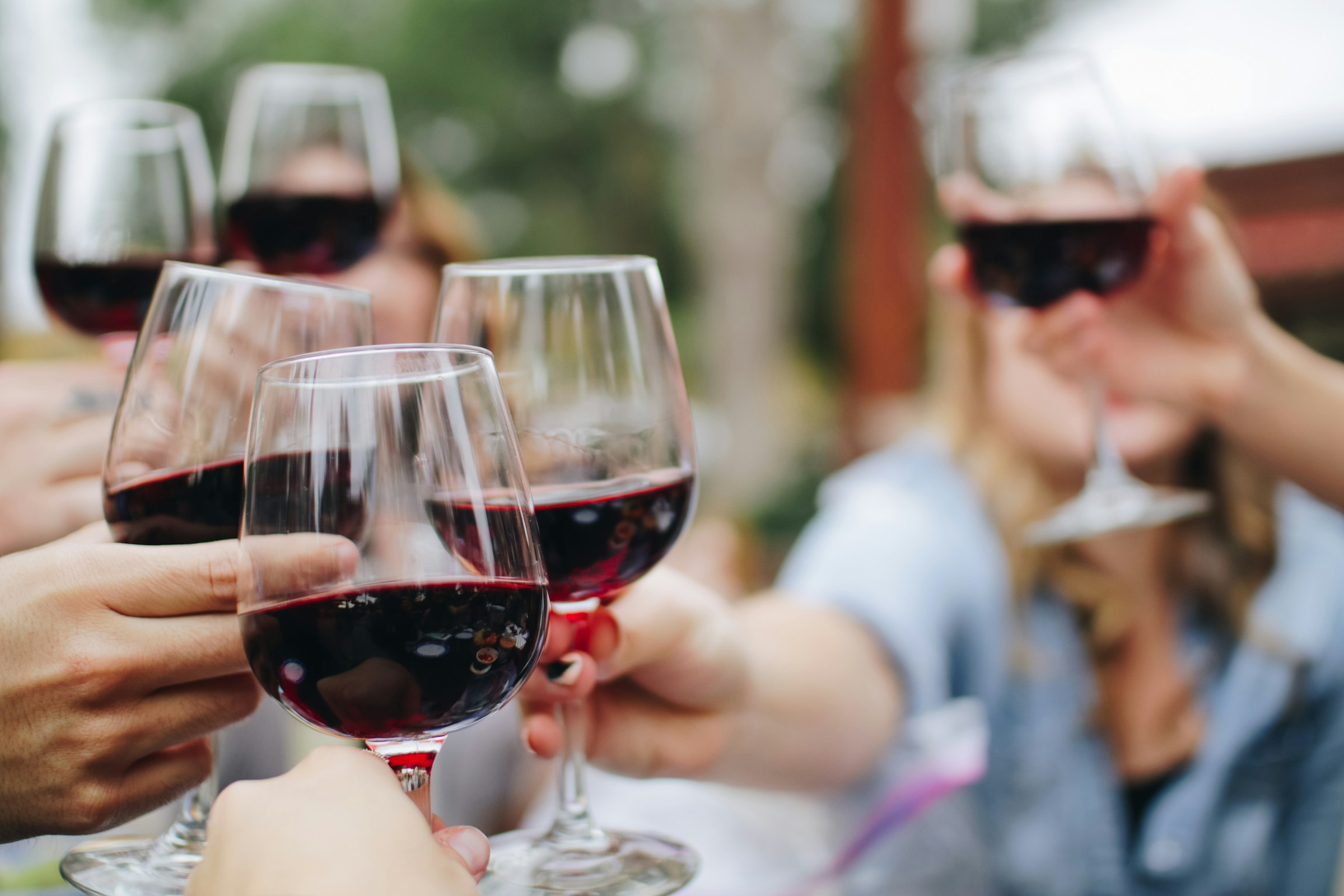 Photo of a wine glass cheers, by Kelsey Night from Unsplash