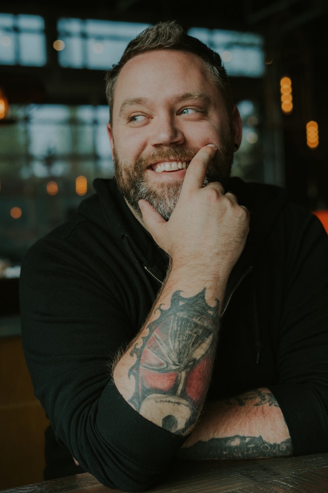 Photo of a man with his hand on his chin, by Lance Reis from Unsplash